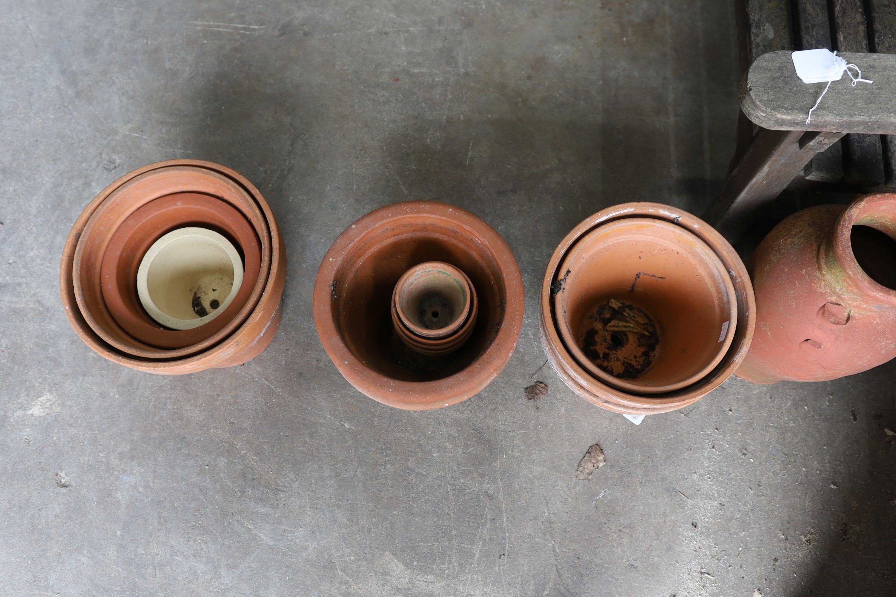 Two Greek style terracotta garden urns, one with iron stand, together with twelve assorted terracotta garden planters